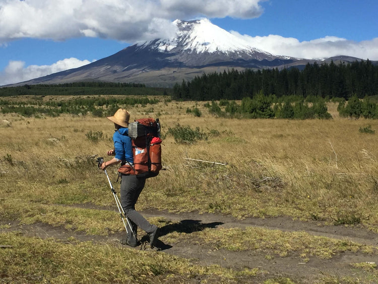 Man hiking a trail wearing Xero Shoes, with mountain in the background