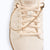 Xero Shoes a Close-up of a Gold Chain Shoe Charm in an Off-white Sneaker